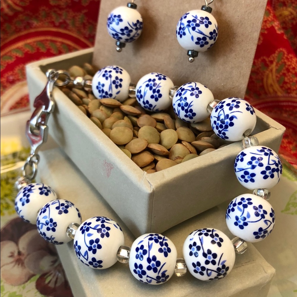 Bracelet with white glass beads with blue flowers.